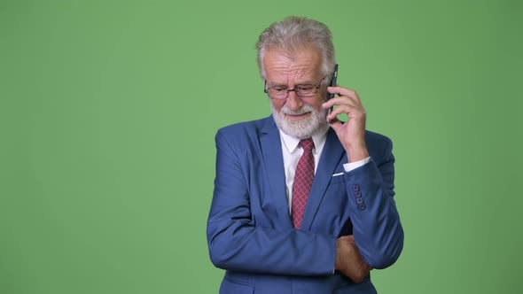 Handsome Senior Bearded Businessman Against Green Background