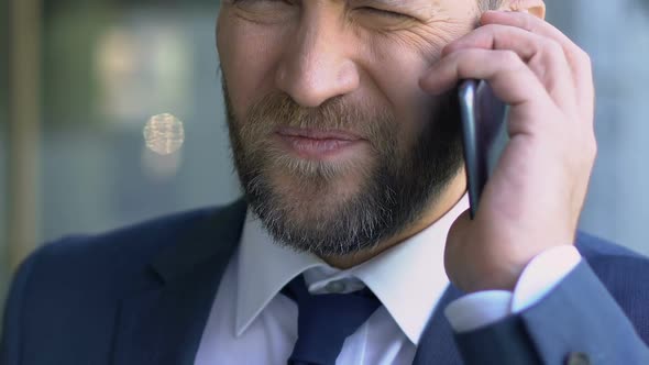 Middle-Aged Boss Suffering From Migraine, Talking on Phone, Headache Close-Up