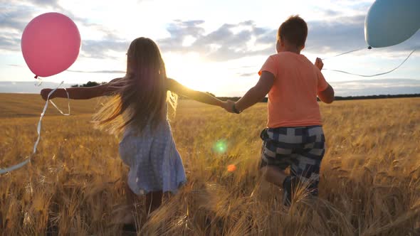 Small Blonde Girl and Red-haired Boy Holding Hands of Each Other and Running Through Wheat Field