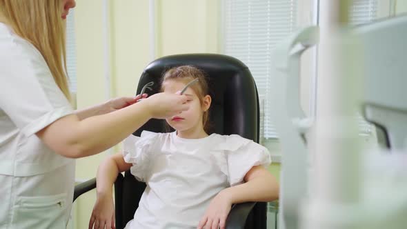 Ophthalmologist Diagnoses Little Girl's Vision and Makes Selection of Lenses