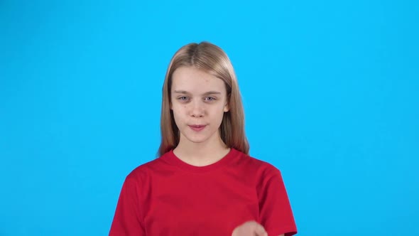 Little Female Posing and Blows Kiss on Blue Background. Slow Motion