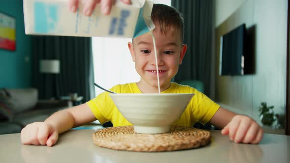 Father Pours Milk on Cereal Prepares Breakfast for His Son