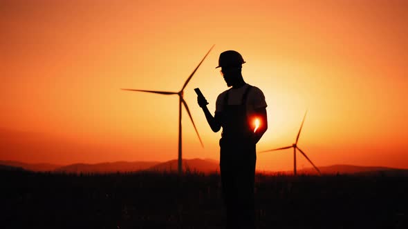 Silhouette African American Industrial Worker Having Mobile Conversation While