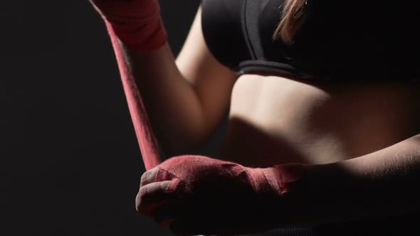 Athletic Female Boxer Pulling the Bandage on Her Hand Muay Thai Martial Art