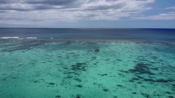 Aerial dolly shot of riding boat on crystal clear transparent ocean water surface,panoramic