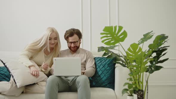 Young Caucasian Couple with Laptop in Their Apartment