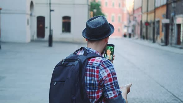 Back View of Tourist Making Video Call on Smartphone