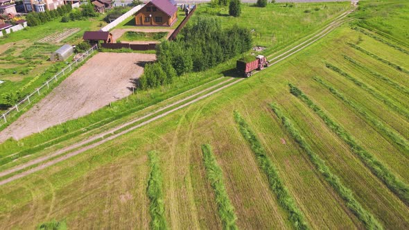 Nice Aerial View of a Tractor Carrying a Cart of Grass in the Field