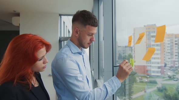 Team of Two Young Business Partners Discussing Strategic Business Directions Talking on the Phone on