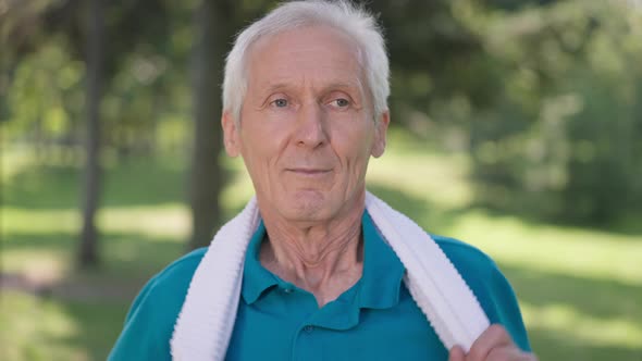 Closeup Satisfied Senior Sportsman Hanging Towel on Shoulders in Slow Motion Smiling Looking at