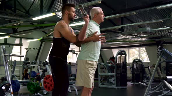 Trainer Controls Exercises of Senior Client