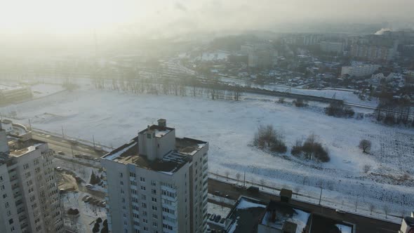 Flight over the city block. Winter cityscape. There is a railway line nearby.