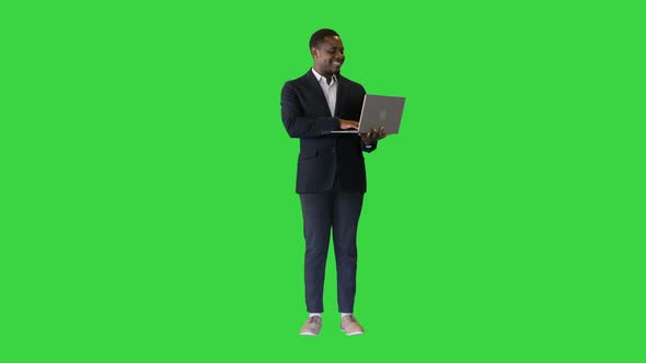 Smiling African American Using a Laptop on a Green Screen Chroma Key