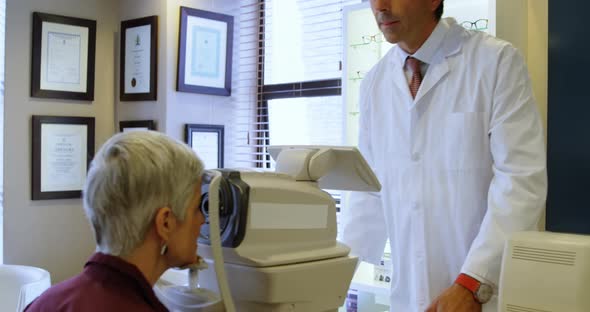 Optometrist examining patient eyes with autorefractors 4k