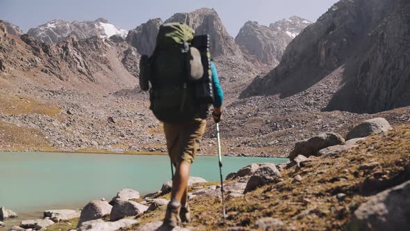 Hiker Tourist with Backpack Walking Near Mountain Lake