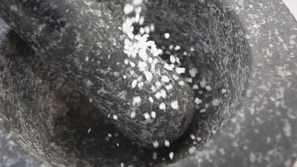 Large Pieces of the Sea Salt Are Falling Into the Grey Stone Mortar