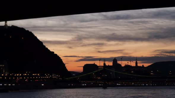 View from a boat sailing under Budapest bridge after sunset, Hungary