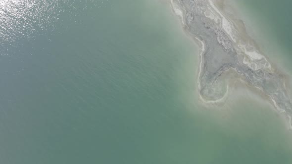 Aerial rotating pull up top down shot of salt shore estuary in the Dead Sea Israel, drone shot