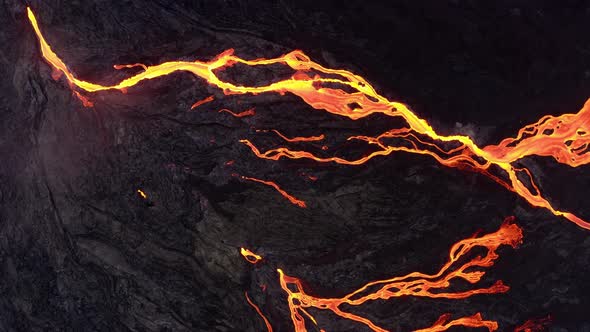 Lava Flow From Black Volcanic Ground On Melted Dark Background - aerial top down