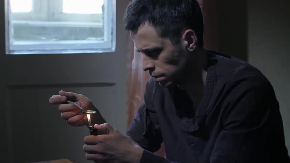 Man Heating Heroin Dose in Spoon with Lighter