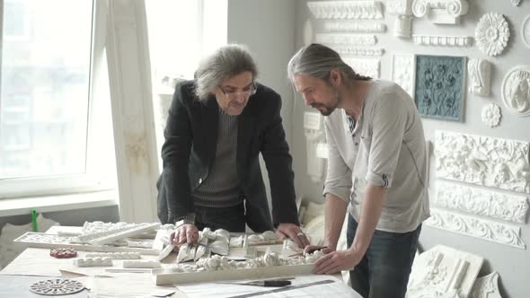 Pair of Male Designers Discussing Molding Samples