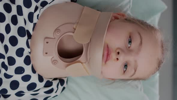 Vertical Video Portrait of Sick Little Patient Resting in Bed Looking at Camera While Having Neck