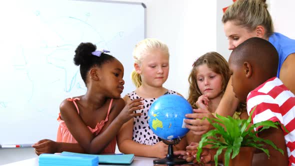 Teacher discussing globe with kids