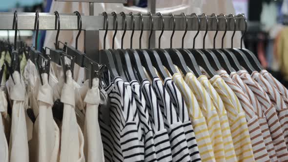 Clothes of Various Sizes Hang on a Hanger in the Store Hung By Color for the Convenience of