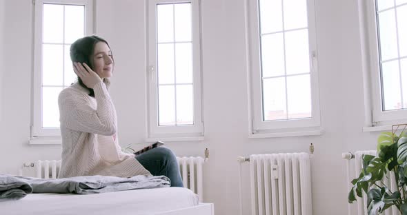 Young woman at home listening to music