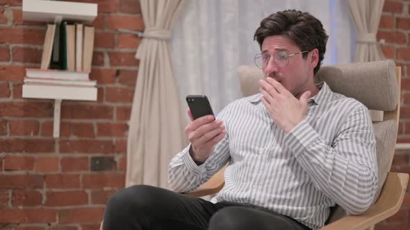 Middle Aged Man having Loss on Smartphone at Home