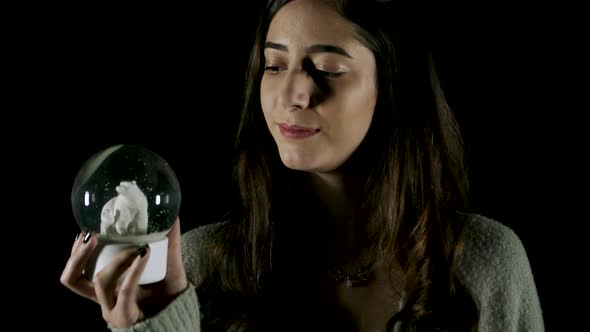 Young woman Twisting and Shaking Snowglobe (Black Screen)