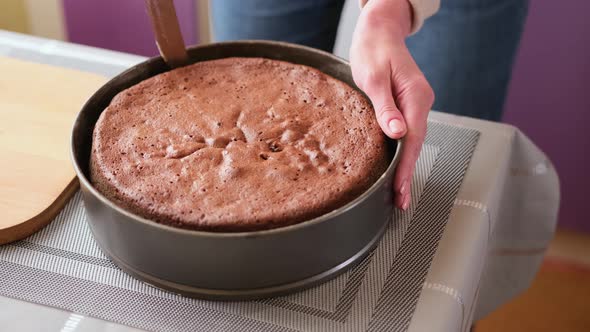 Woman Takes Out a Prepared Cake Crust From a Baking Dish