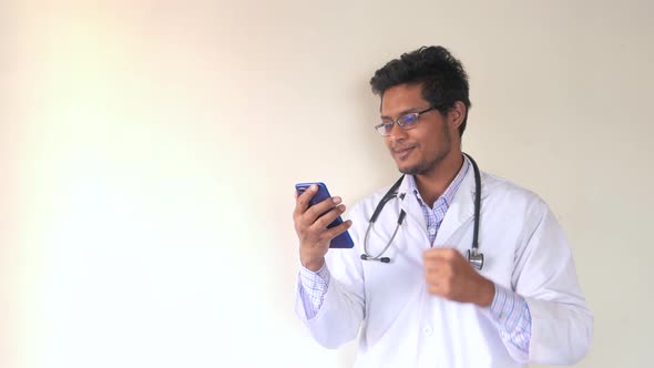 Young Asian Doctor Talking To Smart Shone Camera in Video Chat.