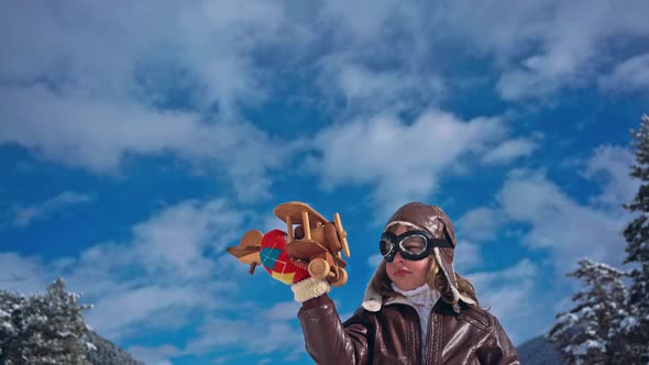 Happy Child Playing with Toy Airplane against Winter Sky Background