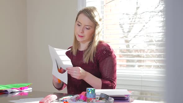 Revealing A Young Blonde Female Cutting Paper With Scissors In Her Craft Room 2