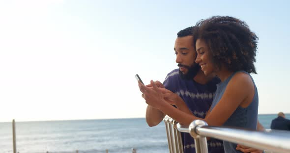 Couple using mobile phone in the beach 4k