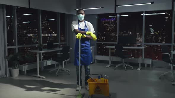 Fulllength View of AfricanAmerican Janitor in Safety Mask Look at Camera Standing in Office