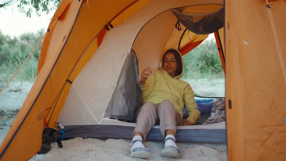 Beautiful Ukrainian Woman in Orange Camping Tent Admiring Morning Sunrise