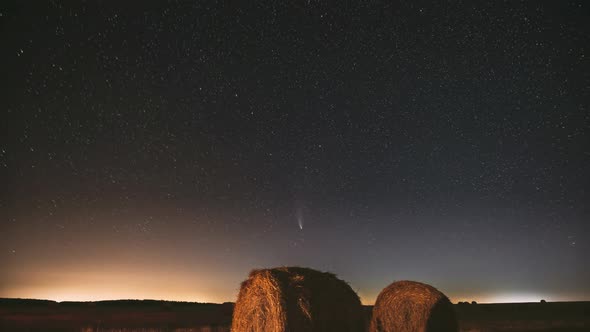 Comet Neowise C2020 F3 In Night Starry Sky Above Haystacks In Summer Agricultural Field