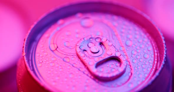 Water droplets on aluminum can of soda or beer with purple lighting 