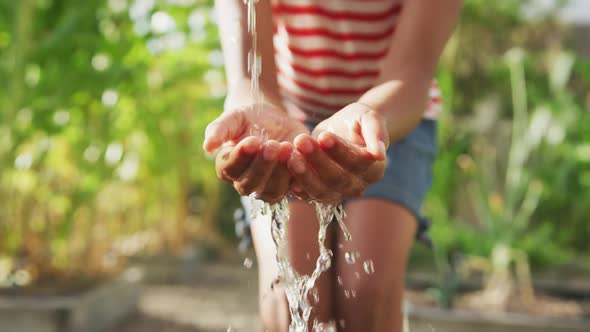 Focus on african American girl washing her hands outside