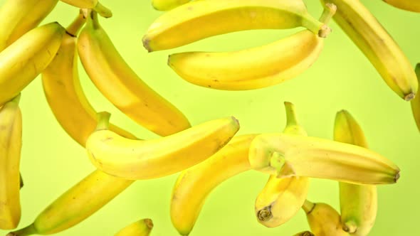 Super Slow Motion Shot of Fresh Bananas on Green Background Flying Towards Camera at 1000Fps