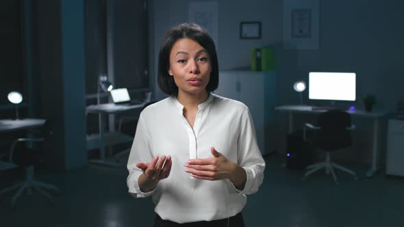 Portrait of AfricanAmerican Businesswoman Look at Camera and Speak Standing in Dark Office