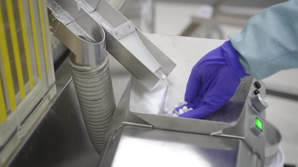 Man Worker Taking White Pills in Hand While Work Day in Pharmaceutical Factory