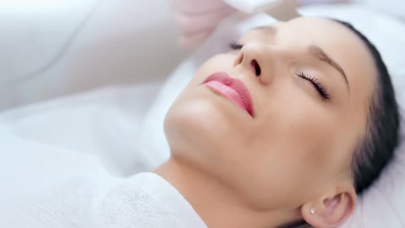 Closeup Beautiful Female Face Enjoying Beauty Ultrasonic Cleansing Procedure at Clinic