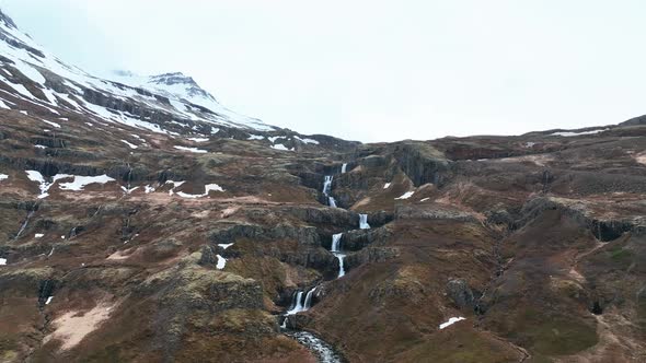 Stunning Nature Scenery Klifbrekku Waterfall In Mjoifjordur, East Iceland. drone ascend