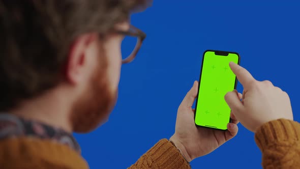 Caucasian Middleaged Man with Facial Hair Using Smart Phone with Green Screen and Gesturing Over