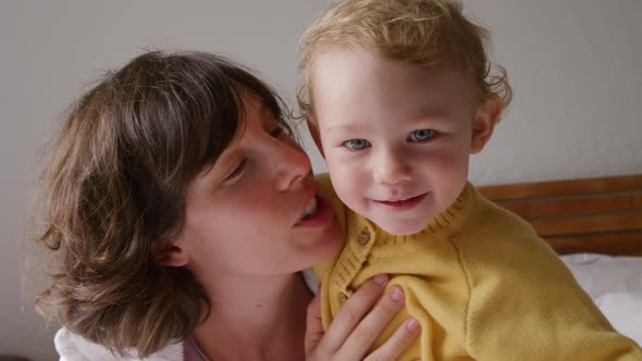 Caucasian woman with her baby at home in bedroom