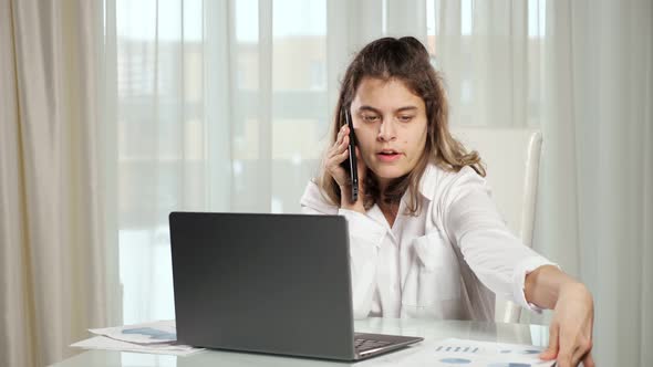 Disabled Woman Talks on Phone Looking at Project Paper