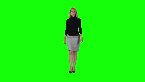 Blonde Girl in Black Turtleneck, Grey Skirt and High Heel Shoes Going Against Green Screen. Slow